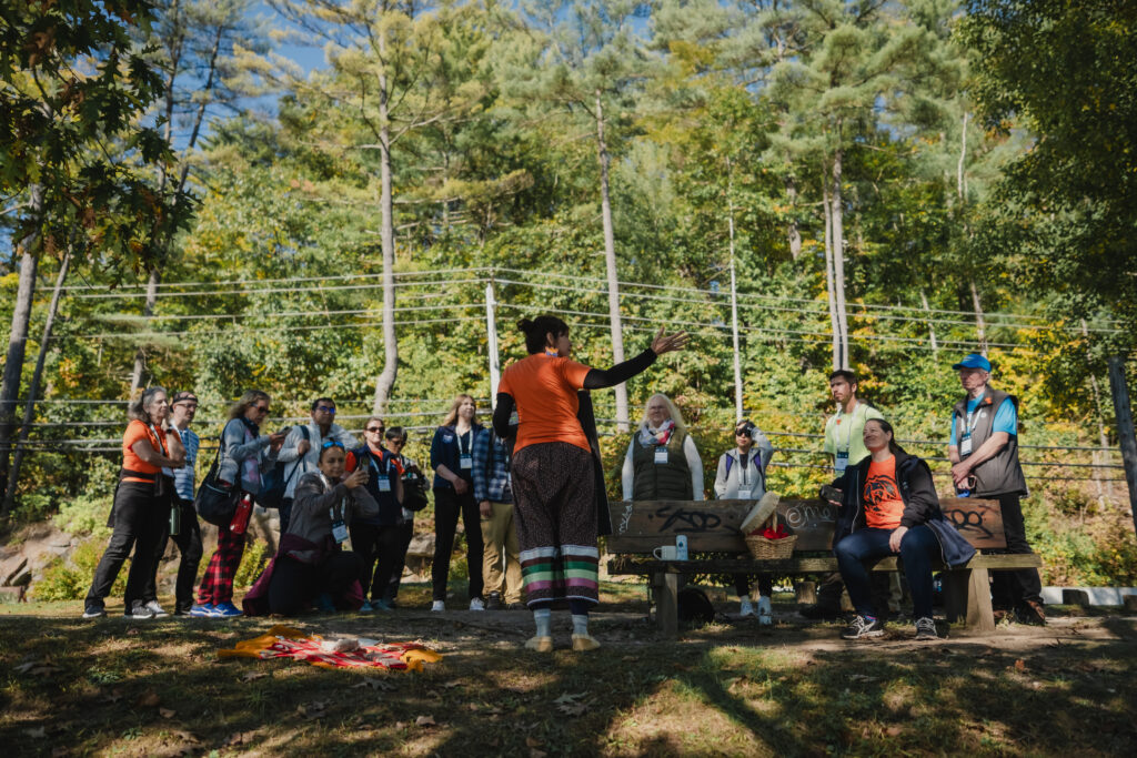 A person leads a presentation on a sunny day on the trail.
